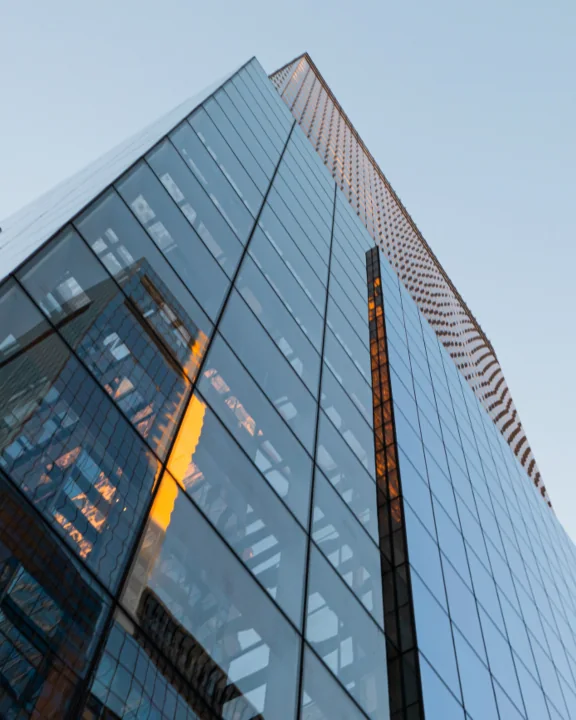 Fachada acristalada de un edificio corporativo al atardecer
